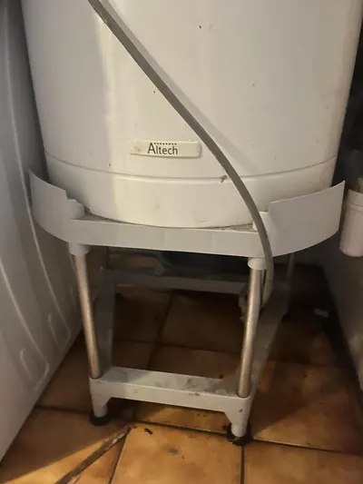 Adoucisseur d'eau installé sur un support dans un local technique, pose complète réalisée par AS Depann avec by-pass et évacuation