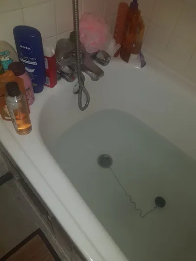 Baignoire remplie d'eau stagnante qui ne s'évacue plus, symptôme d'une colonne d'immeuble bouchée comme AS Depann en débouche dans les villes de la vallée du Gier