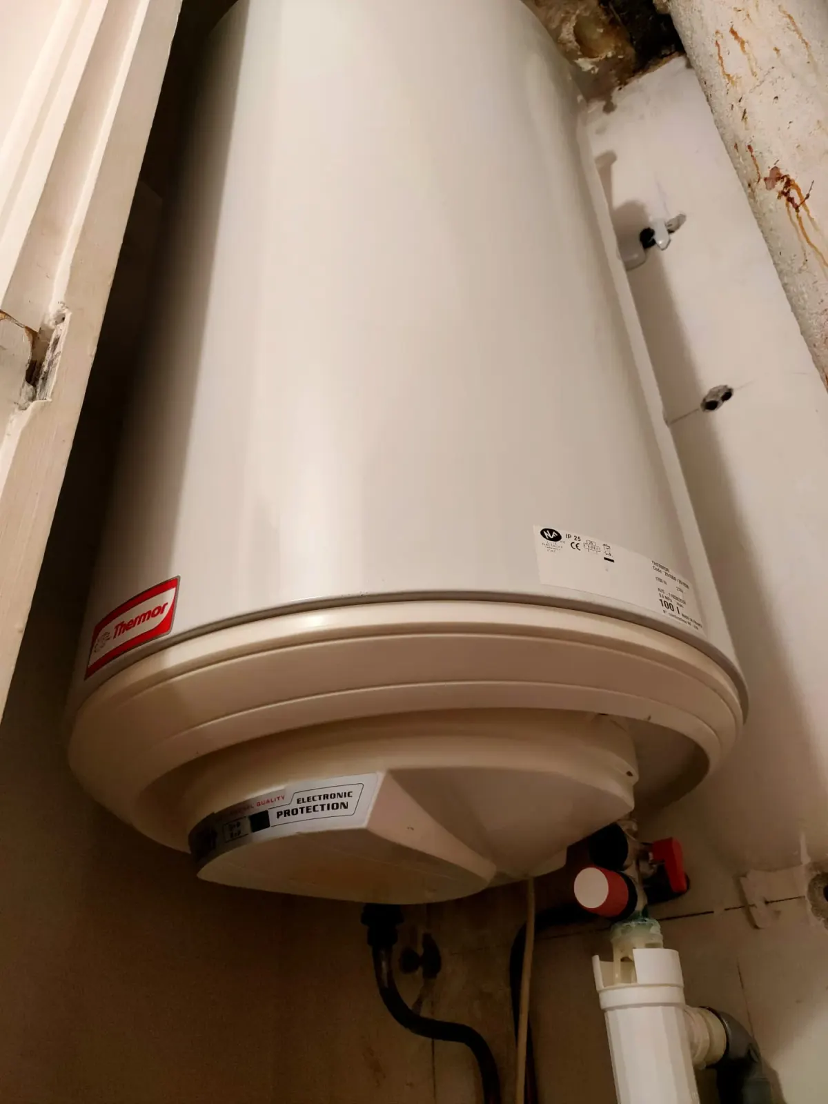 Chauffe-eau électrique beige ancien fixé au mur avec raccords dessous, page chauffe-eau eau tiède par AS Depann