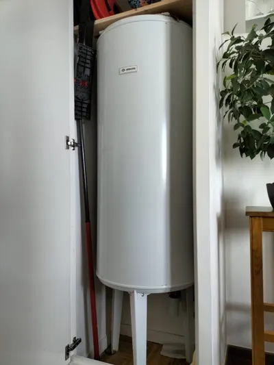 Chauffe-eau électrique blanc dans un placard de cuisine porte ouverte, diagnostic d'absence d'eau chaude réalisé par AS Depann