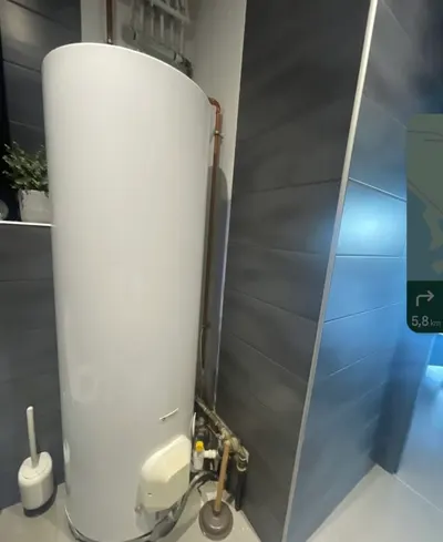 Chauffe-eau vertical installé dans un placard de salle de bain avec porte miroir, remplacement réalisé par AS Depann dans un logement géré par une agence