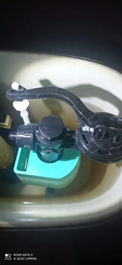 Clapet anti-retour noir sur une évacuation, vu de dessus avec sa cuve turquoise, équipement posé par AS Depann sur un poste de relevage