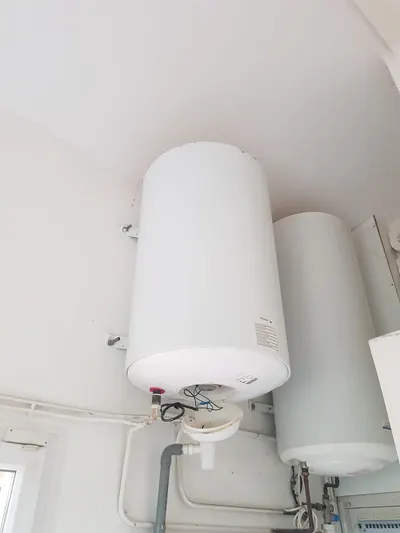 Deux chauffe-eau électriques verticaux côte à côte fixés au mur d'un local technique, installation collective suivie par AS Depann pour un gestionnaire