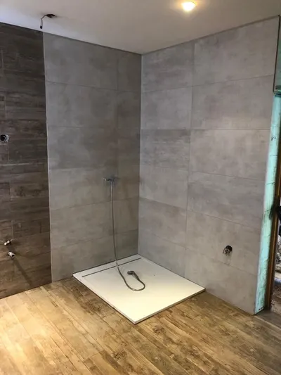 Douche à l'italienne en cours de création avec receveur extra-plat posé et carrelage bois, chantier AS Depann