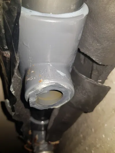 Manchon PVC gris neuf collé sur une évacuation en plafond de cave après réparation d'une fuite par AS Depann
