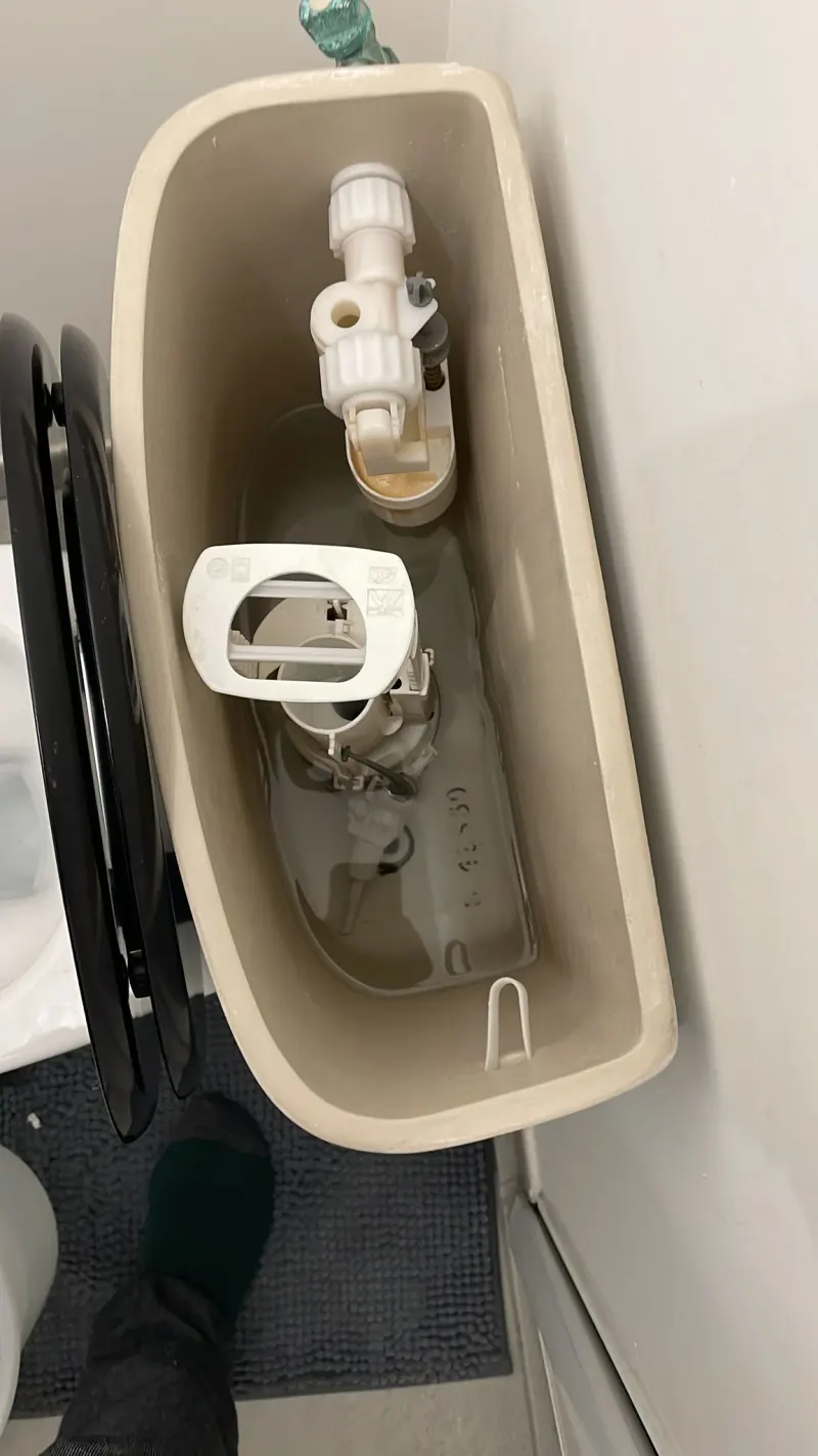 Intérieur d'un réservoir de WC avec mécanisme de chasse d'eau neuf posé par AS Depann lors d'un dépannage de toilettes