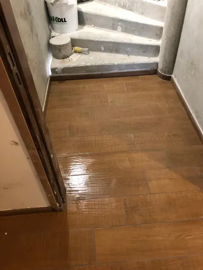 Parquet ancien gonflé et taché par une infiltration d'eau dans un couloir, dégât des eaux constaté par le plombier AS Depann