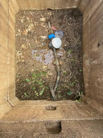 Regard de compteur d'eau ouvert dans une pelouse lors d'une recherche de fuite après compteur par AS Depann près de Millery