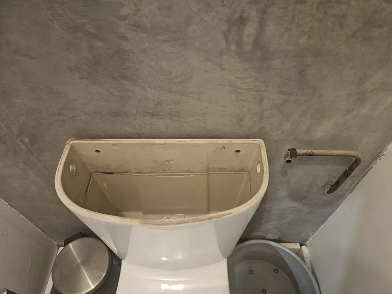 Réservoir de chasse d'eau ouvert sans couvercle pendant le remplacement du mécanisme par AS Depann, WC qui coulait en continu
