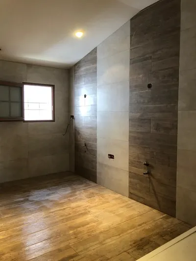 Salle de bain en rénovation avec parement bois, attentes de douche et sol brut, chantier AS Depann avant carrelage