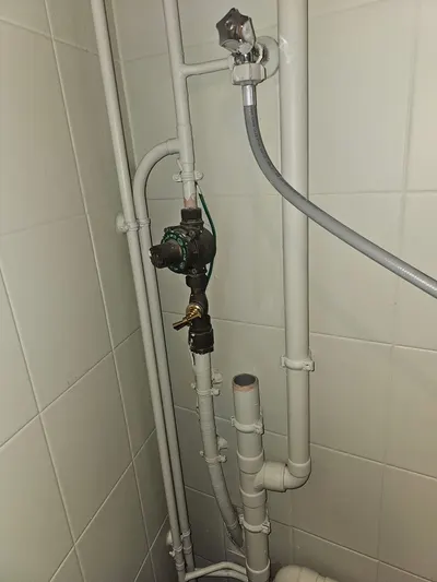 Vanne d'arrêt et canalisation d'alimentation en PVC pression le long d'un mur carrelé, vanne d'arrêt accessible posée par AS Depann