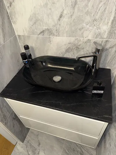 Vasque noire à poser sur meuble blanc avec mitigeur chromé, salle de bain marbre, installation AS Depann