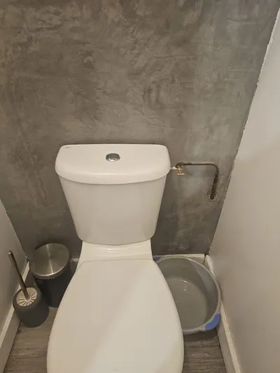 WC à poser neuf avec réservoir dans un coin de pièce en béton ciré, alimentation en cuivre, pose réalisée par AS Depann