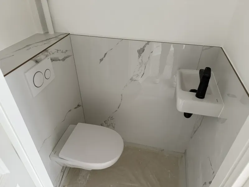 Toilettes rénovées avec WC suspendu et lave-mains, remise en état effectuée par AS Depann après un dépannage de sanitaires le dimanche